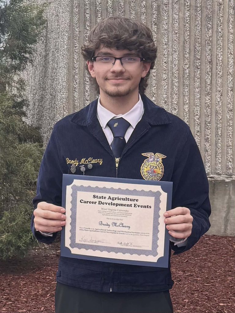 student poses with award