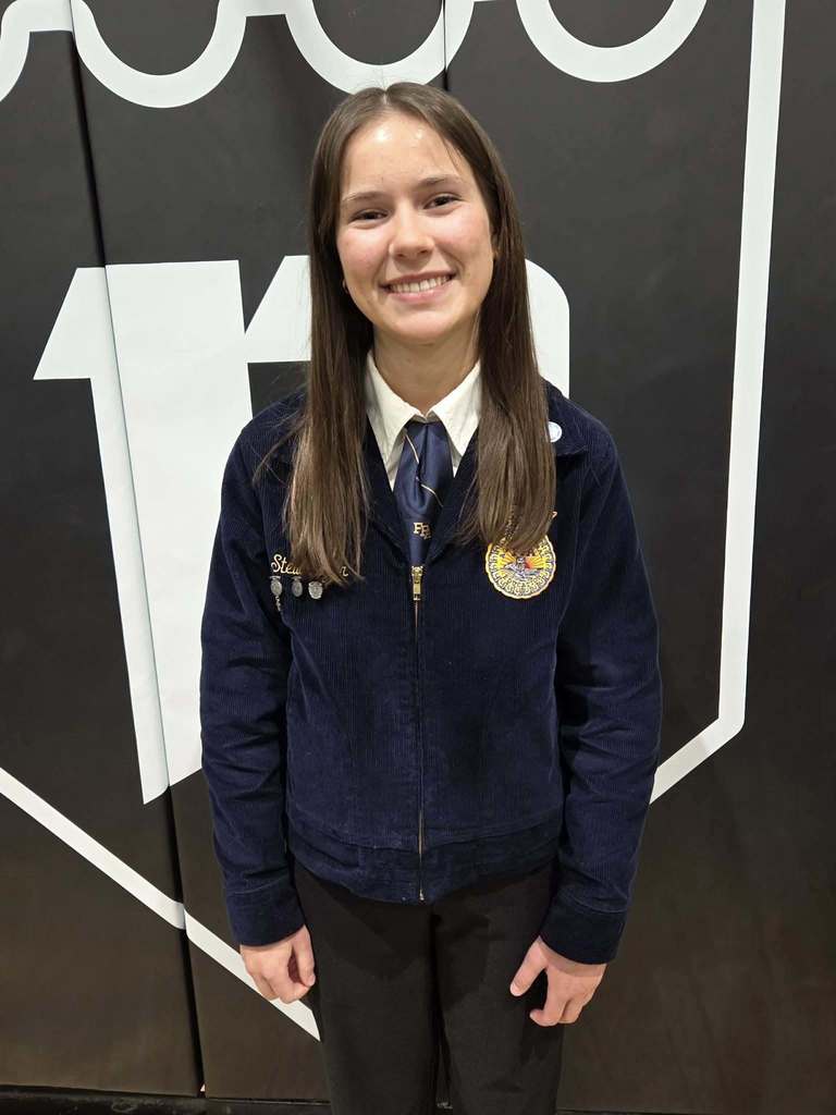student poses with award