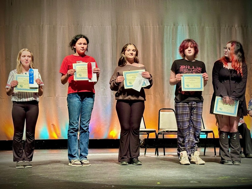 student poses with award