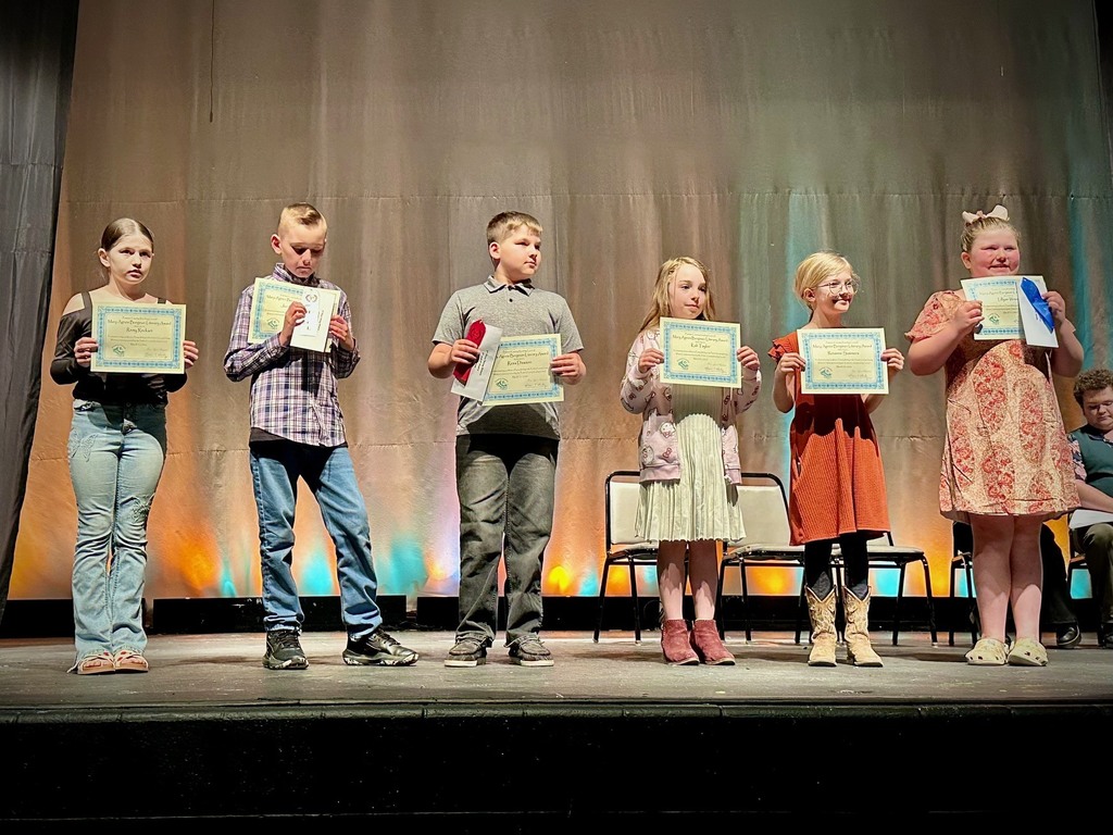 student poses with award