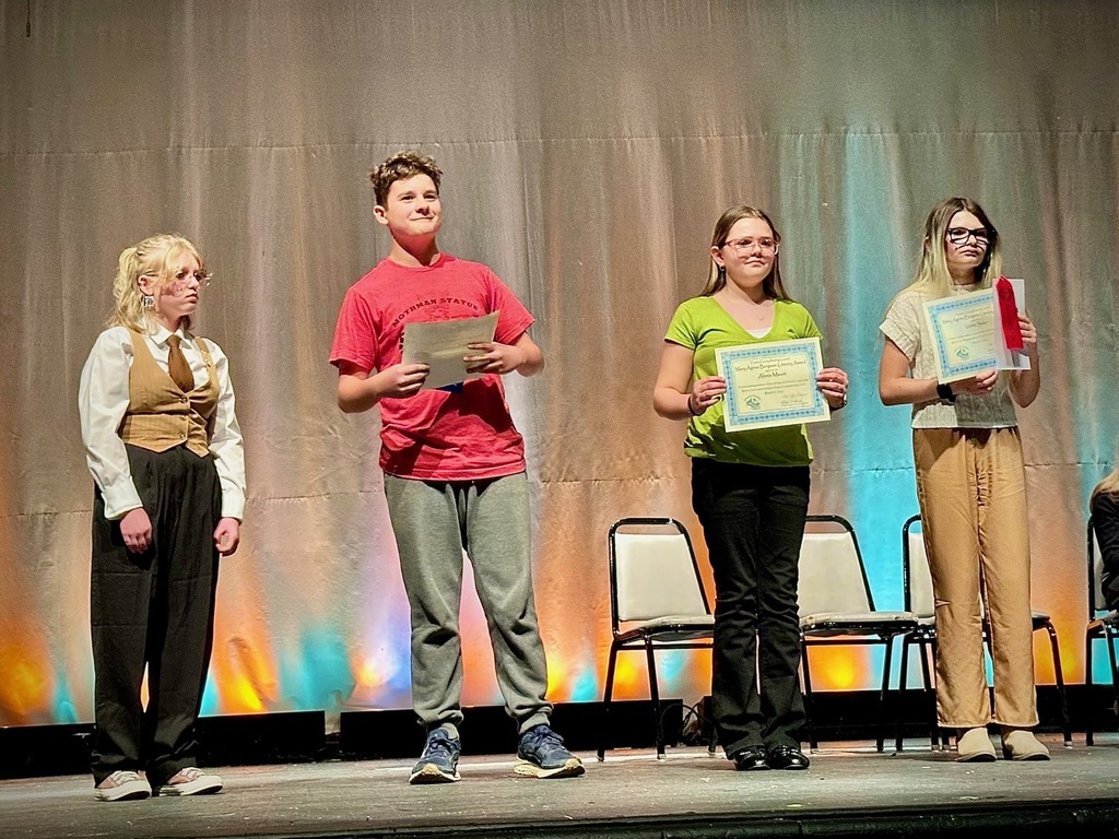 student poses with award