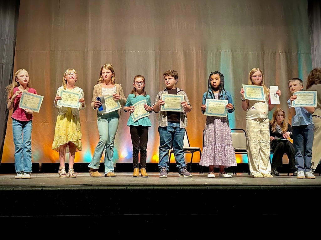 student poses with award