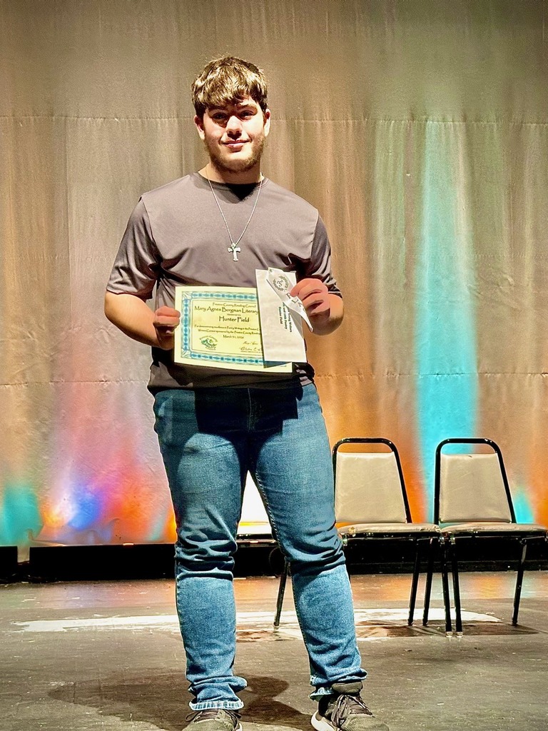 student poses with award
