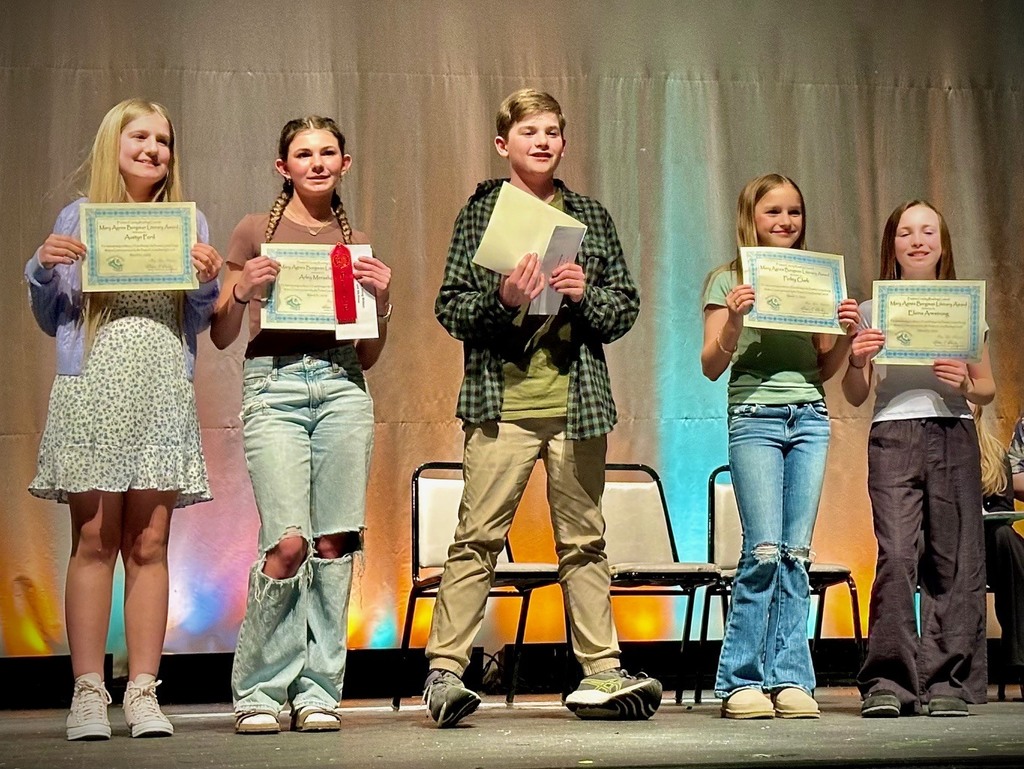 student poses with award