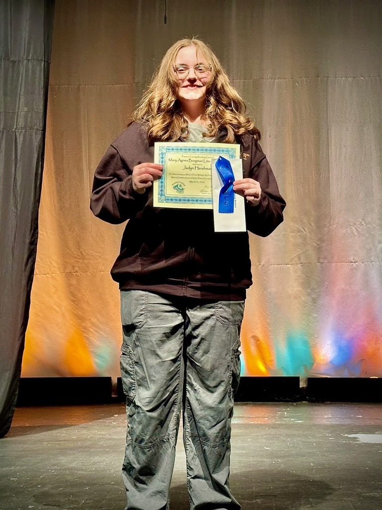 student poses with award