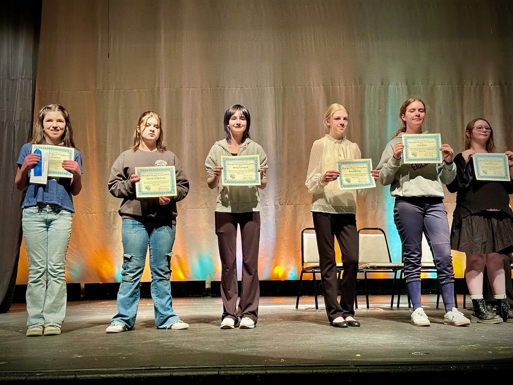 student poses with award