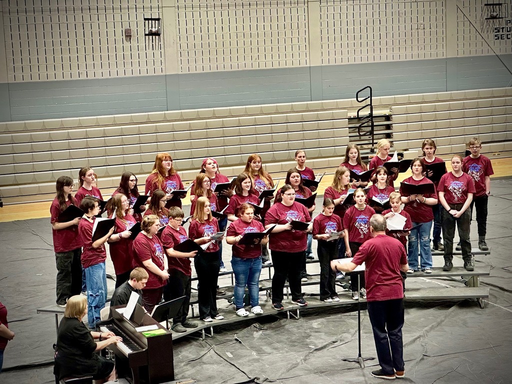 a high school choir sings in a gym