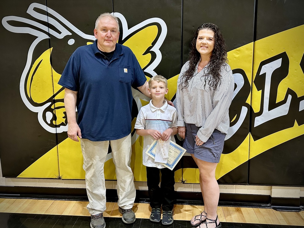 student poses with award
