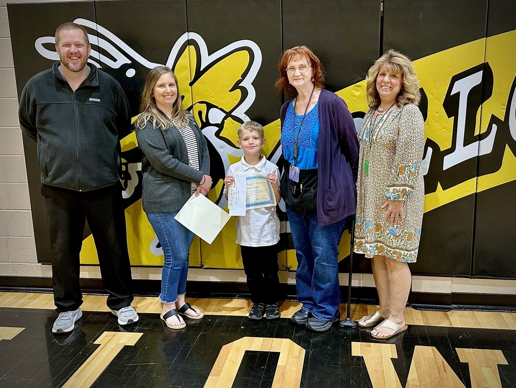 student poses with award