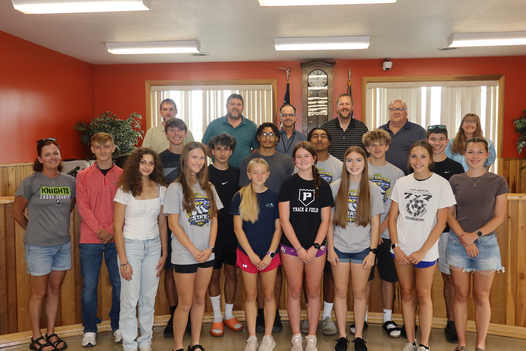 students pose with board members to be recognized for achievement