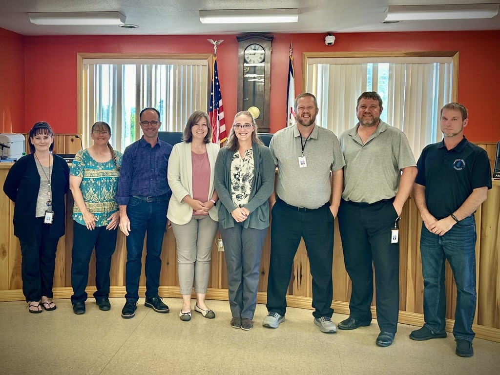 staff posing with board