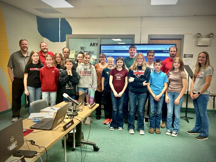 students pose with board members for recognition at a meeting