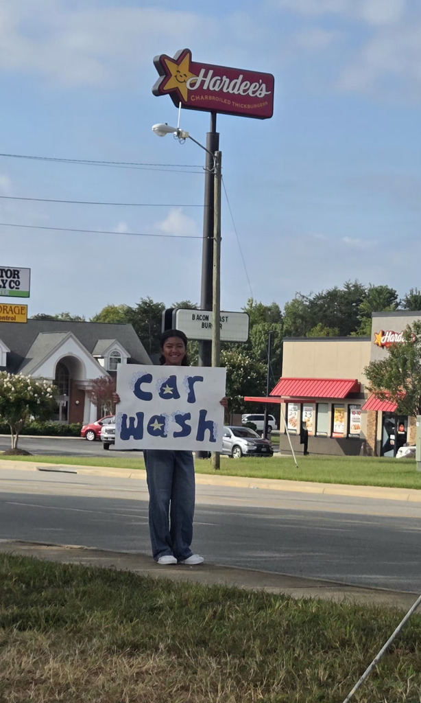 female student holding carwash sign