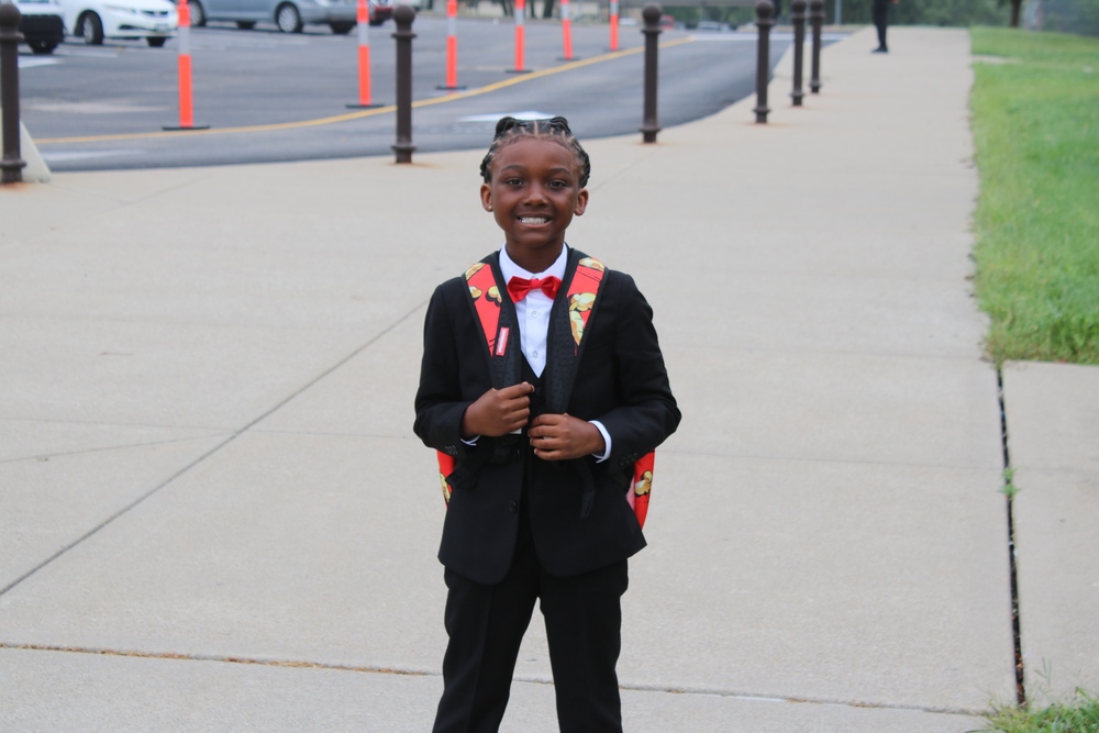Springdale student arriving to school in a full suit, white shirt, and red bow tie.