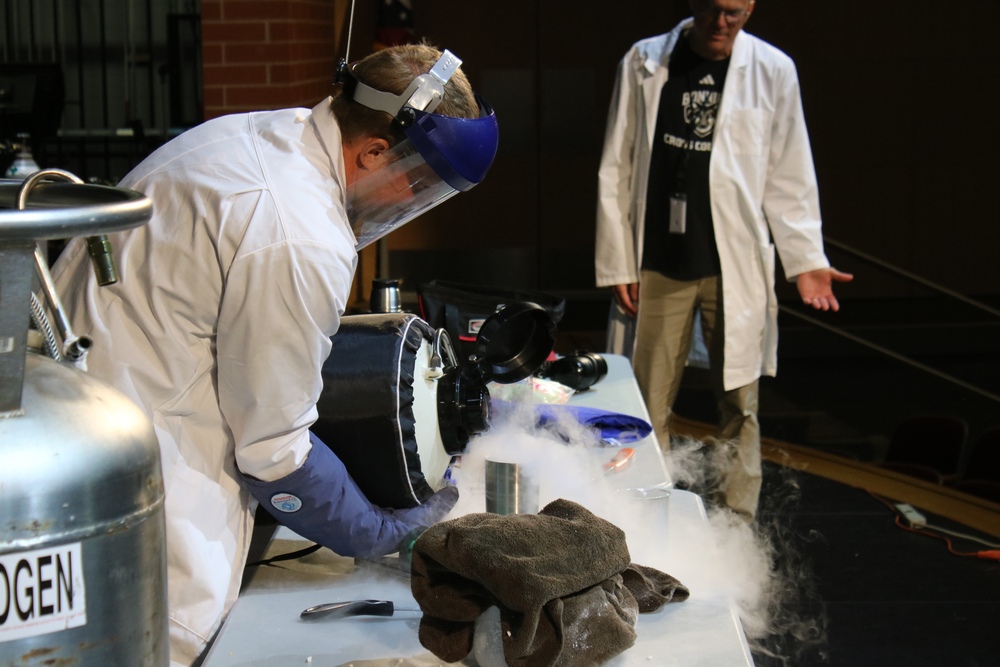 Princeton Community Middle School Teacher Mr. Watson pours liquid nitrogen into Mr. Chilcote's coffee cup.