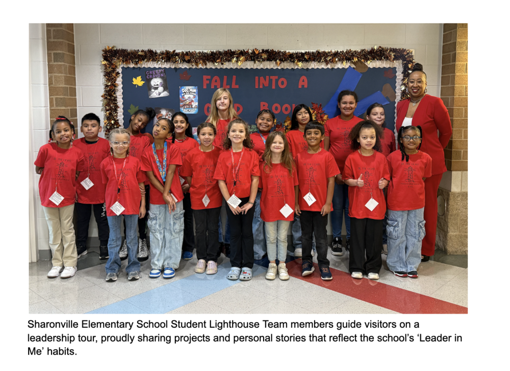 Sharonville Elementary School Student Lighthouse Team members stand in front of a bulletin board near the entrance to the elementary school.