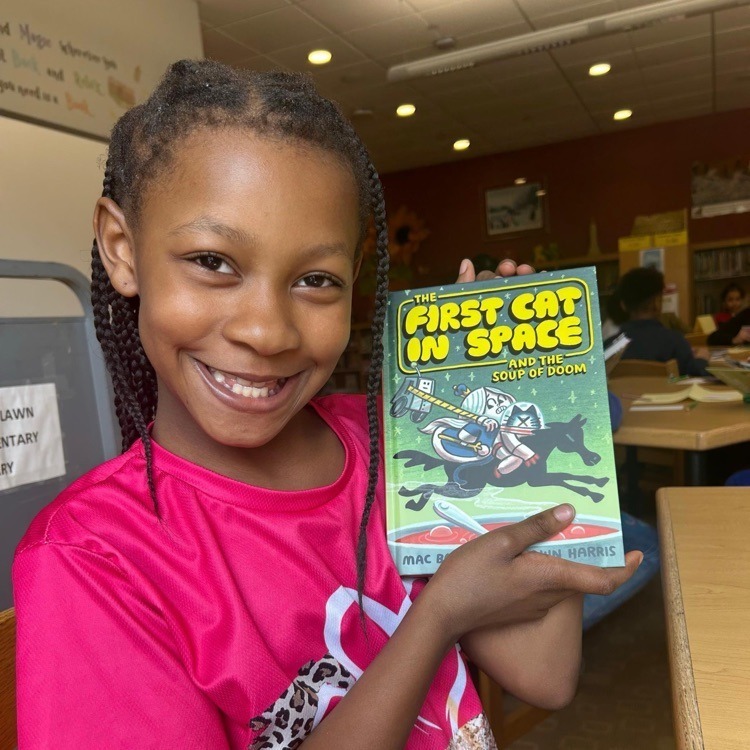 Woodlawn Student holding up First Cat in Space book.