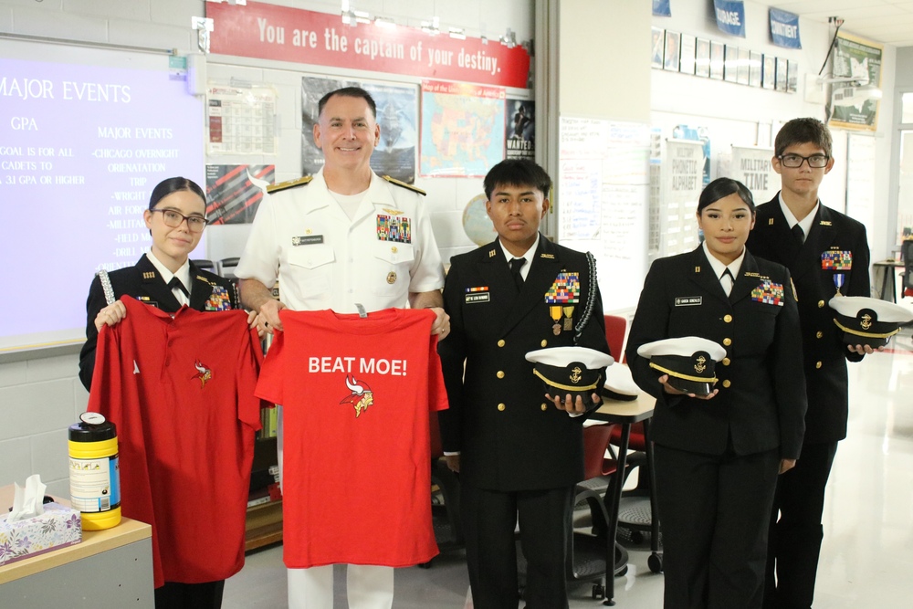 Rear Admiral Matthew Pottenburgh poses with four Princeton NJROTC cadets in full uniform while holding Princeton shirts.