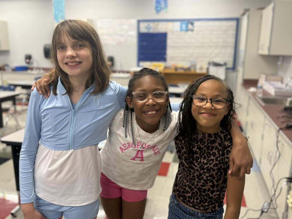 Three Sharonville Elementary students in classroom posing for a photo