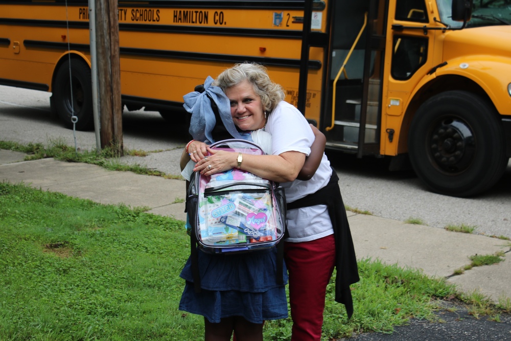 Glendale teacher hugs Glendale student after students gets off the bus on the second day of school