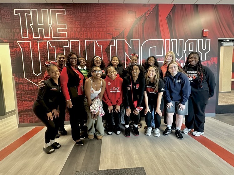 Dr. Phillips with students in front of wall they helped design