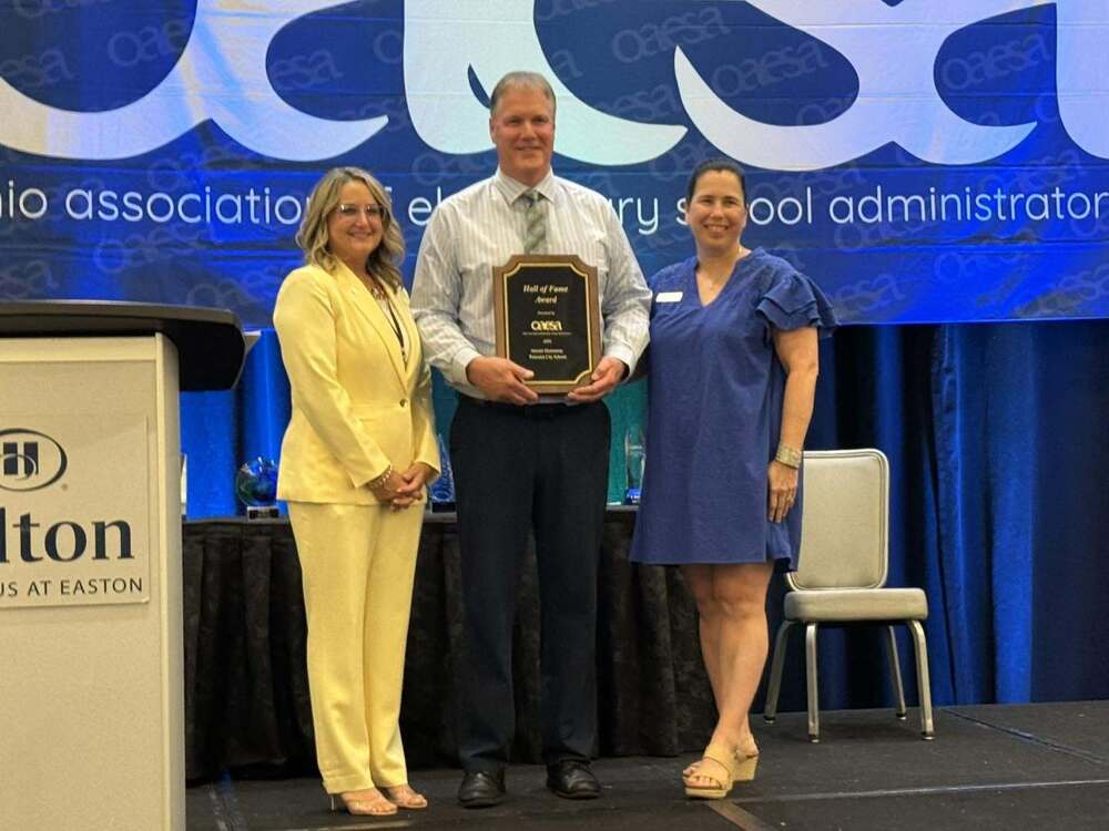 Stewart Elementary Principal Dennis Ramsay with two other people accepting the OAESA Hall of Fame School Plaque in Columbus