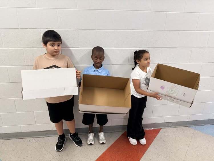 Three Sharonville Elementary students holding recycling boxes