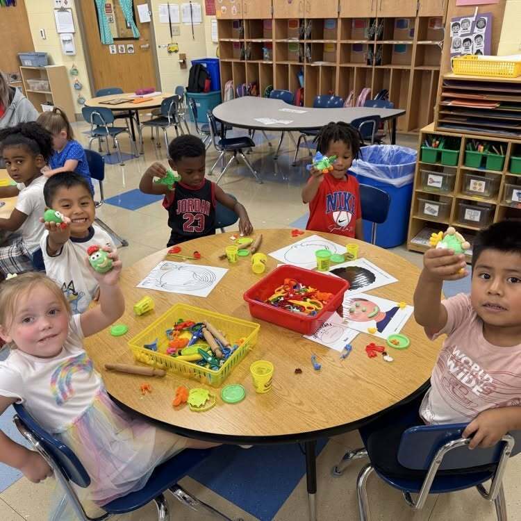 Springdale Students holding up their Play Doh Creations on Play Doh Day