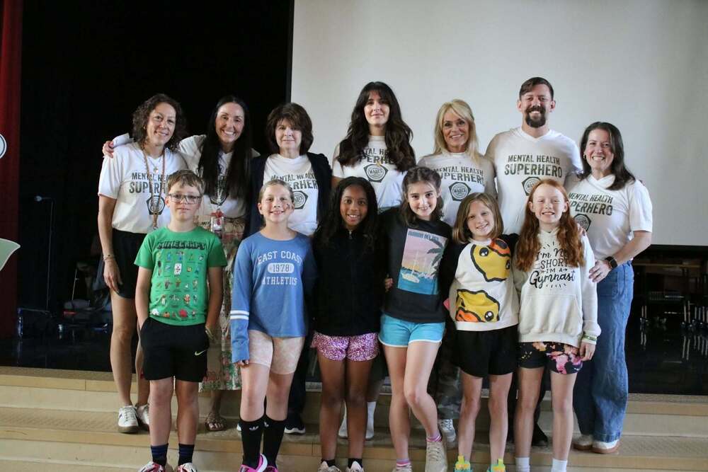 Members of Evendale Elementary's Hope Squad, with advisor Rachel Schadel, standing in the auditorium with members from Madi's House.