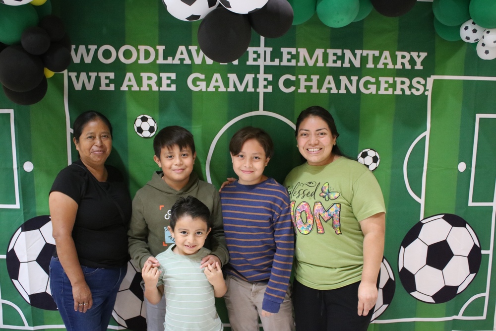 A Woodlawn Elementary family in front of a soccer themed backdrop