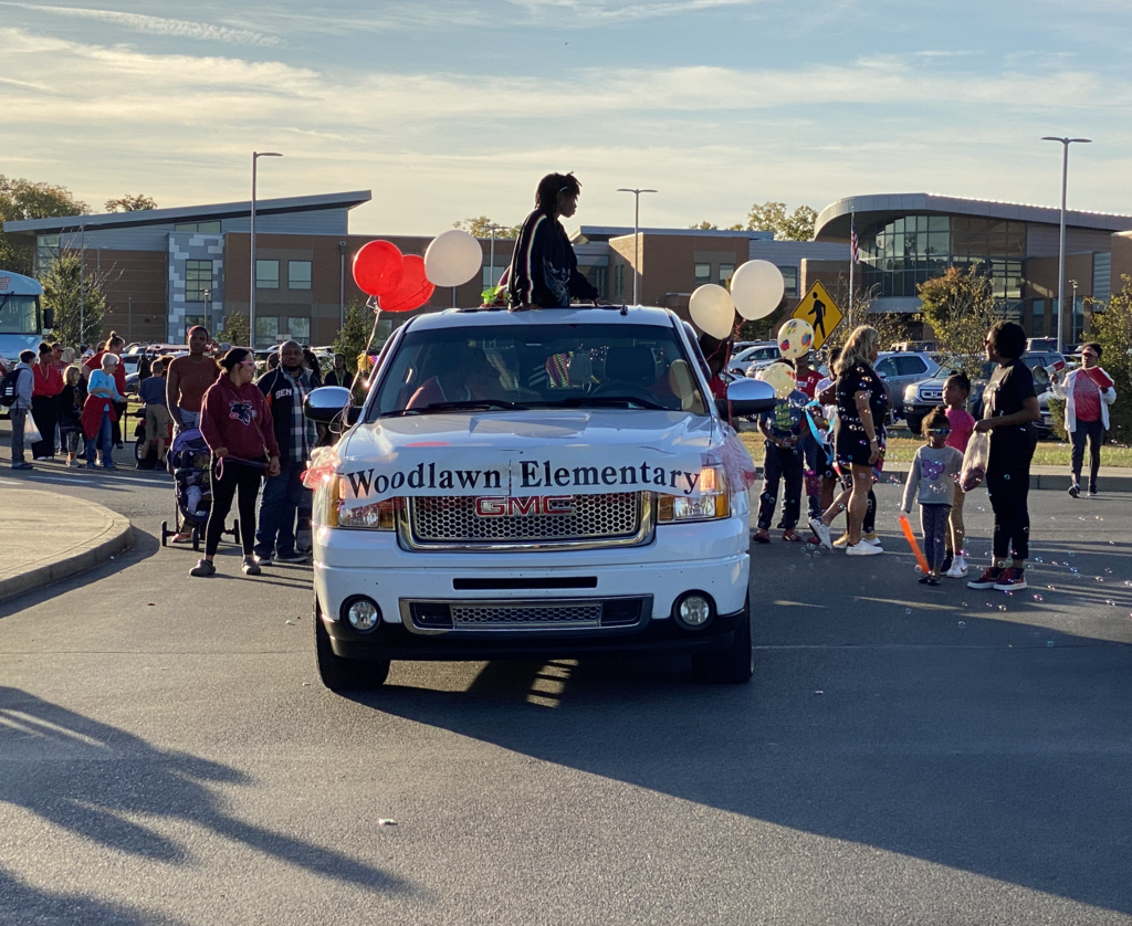 Woodlawn Elementary Truck and float with students popping out of sunroof and surrounding the truck as it heads out of Viking Village in the Homecoming Parade in 2004. Th