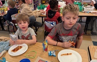 students eating pizza in a classroom