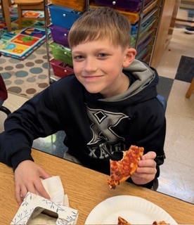 students eating pizza in a classroom