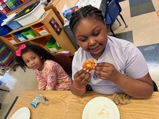 students eating pizza in a classroom