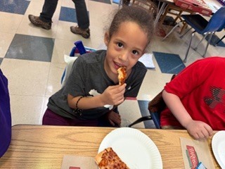 students eating pizza in a classroom