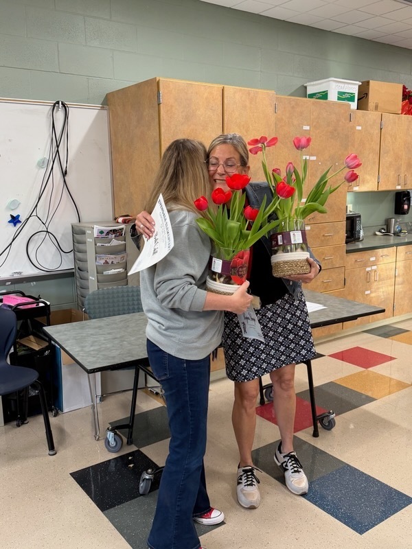 people holding flowers and awards 