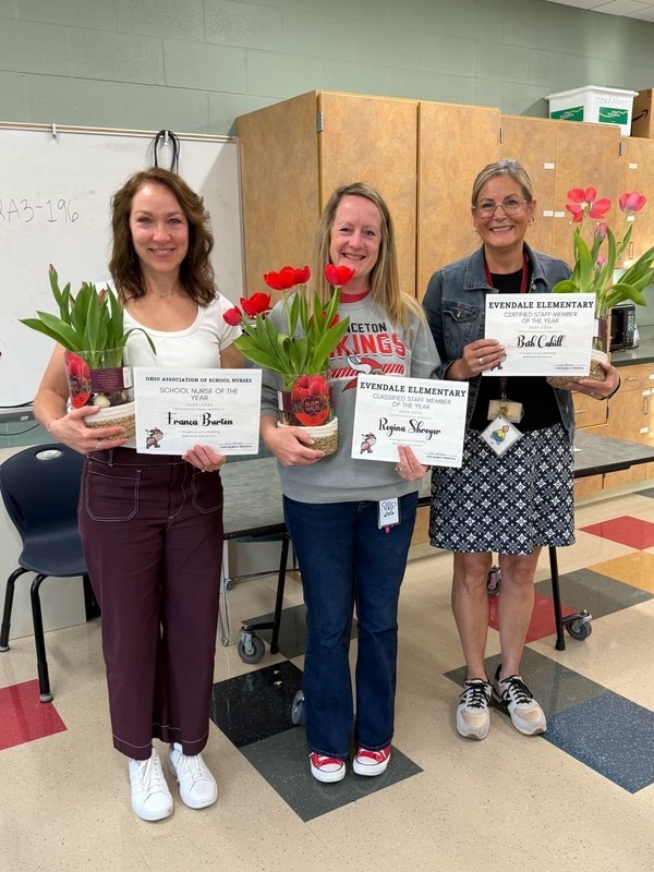 people holding flowers and awards 