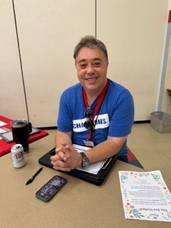 person in a blue shirt sitting at a table
