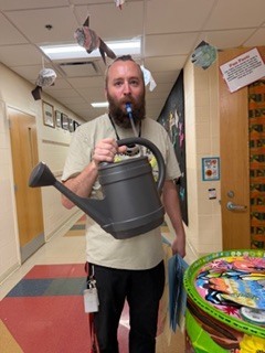 a person drinking water out of a watering can 