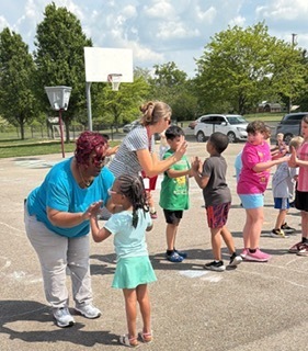 students and staff on the playground dancing
