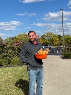 person outside holding an orange bowl