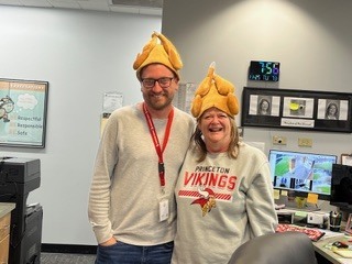 two people wearing turkey hats in an office area 
