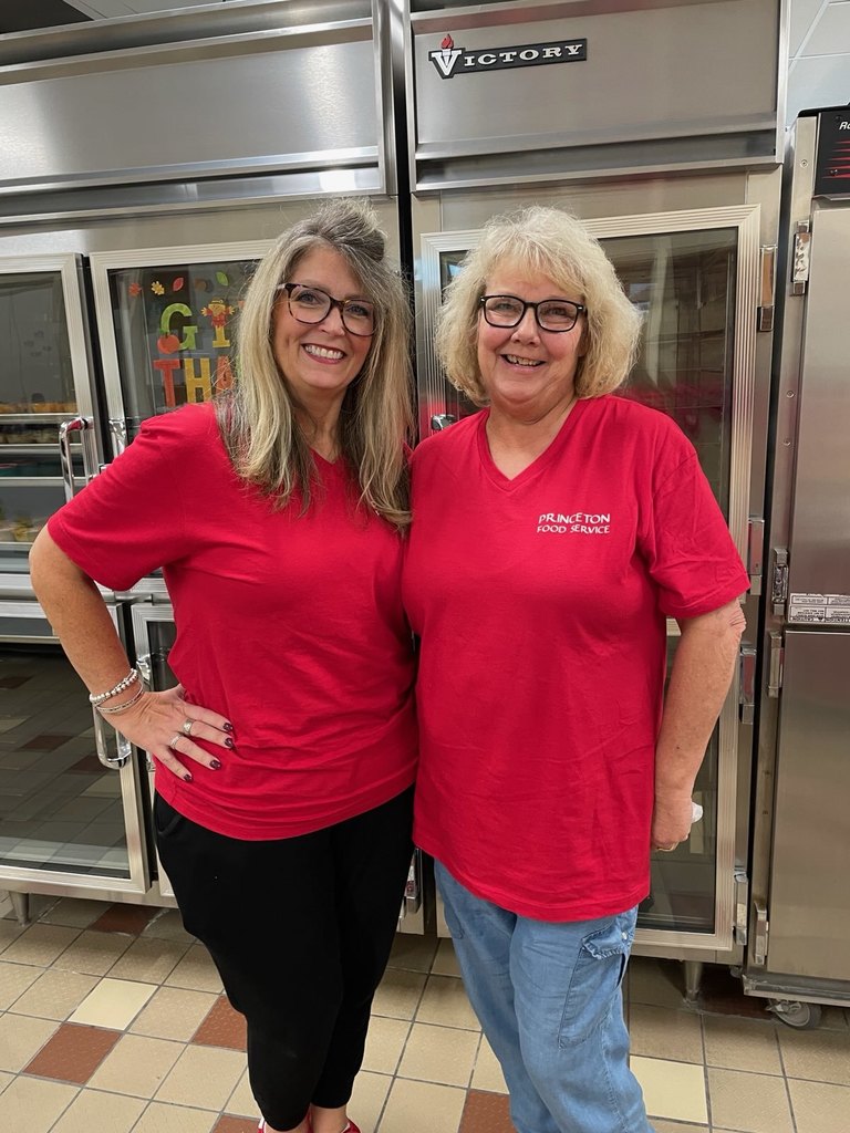 two people dressed in red shirts in front of a freezer