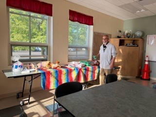person standing in front of a table filled with chips, salsa and sodas 