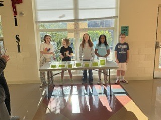 people standing in front of a table with bins on it. 