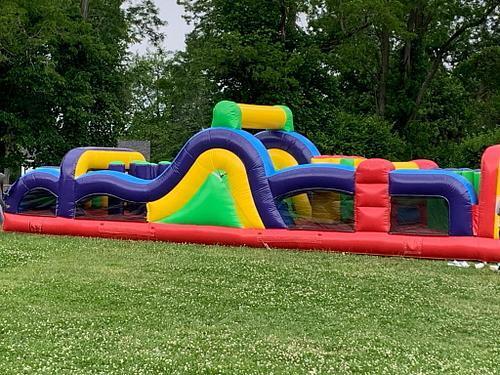 inflatable structure on grass with trees behind it. 