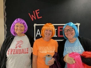 three people wearing colorful wigs 