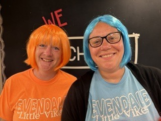 two people wearing colorful wigs 
