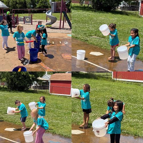people in matcing shirts using buckets and water