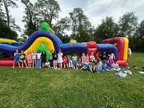 people standing in front of a colorful bouncy house